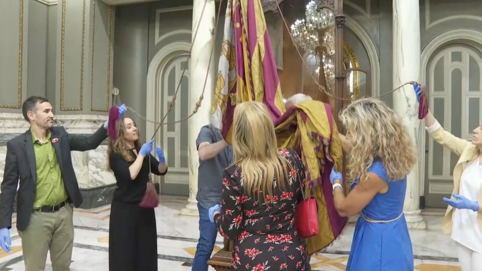 Diversos regidors col·laboren en el traslladat de la Senyera que l'alcalde ha depositat en el Saló de Cristall