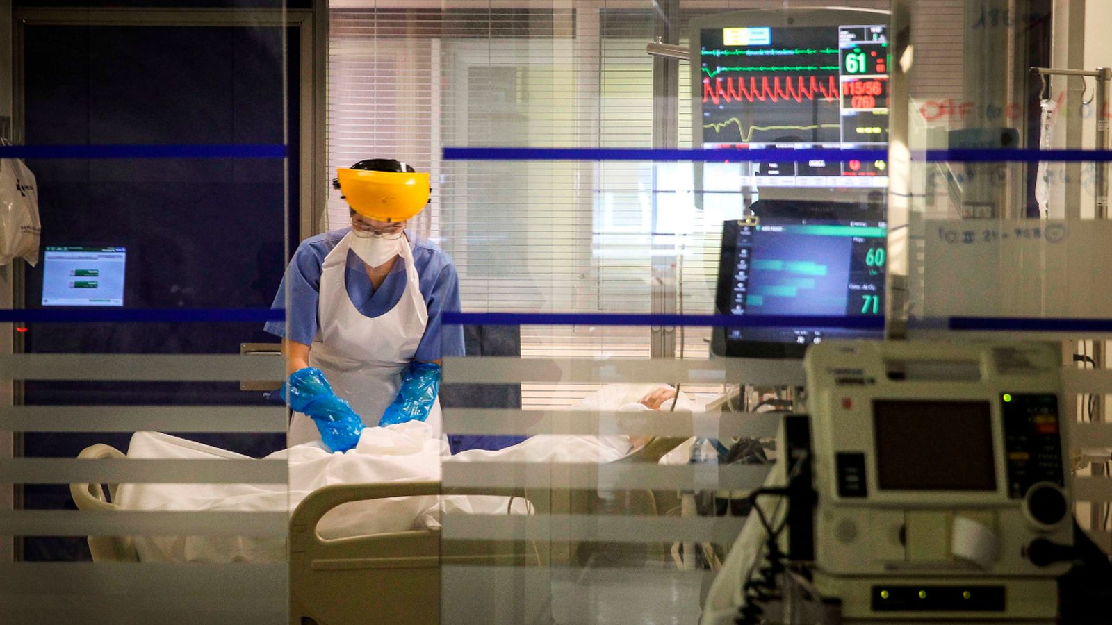 Imatge d'arxiu d'una sanitària atenent a un pacient en l'UCI
