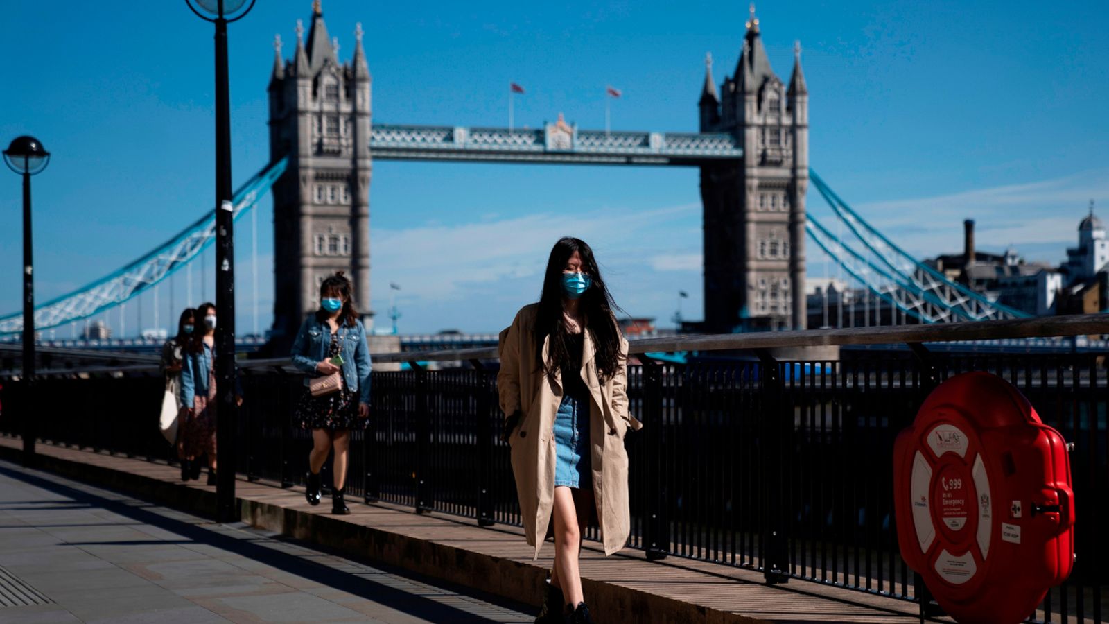 Un nombre reduït de persones passegen davant el 'Tower Bridge' a Londres