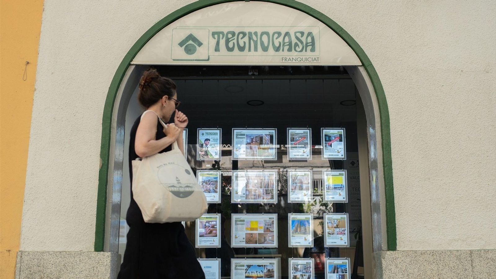 Una jove passa per davant d'una immobiliària Observatori Emancipacío Joves