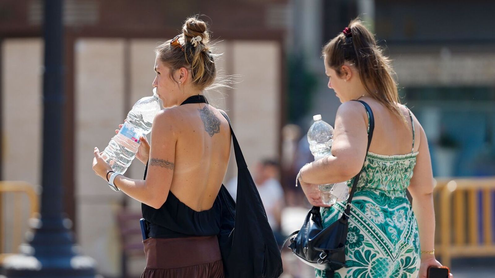 Dos xiques es refresquen amb aigua a València
