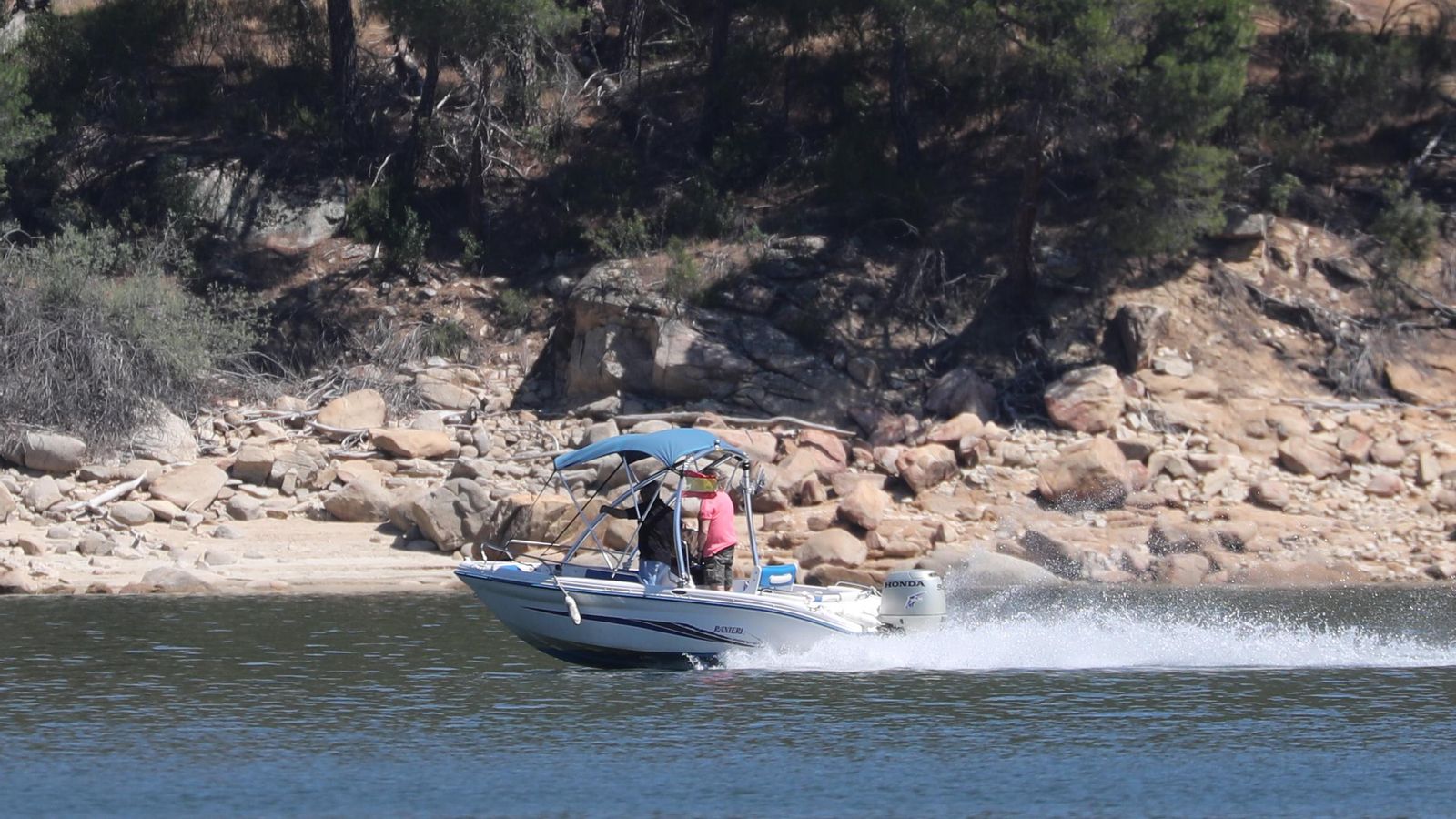 Un grup de persones busquen la xiqueta en una llanxa en el pantà de San Juan
