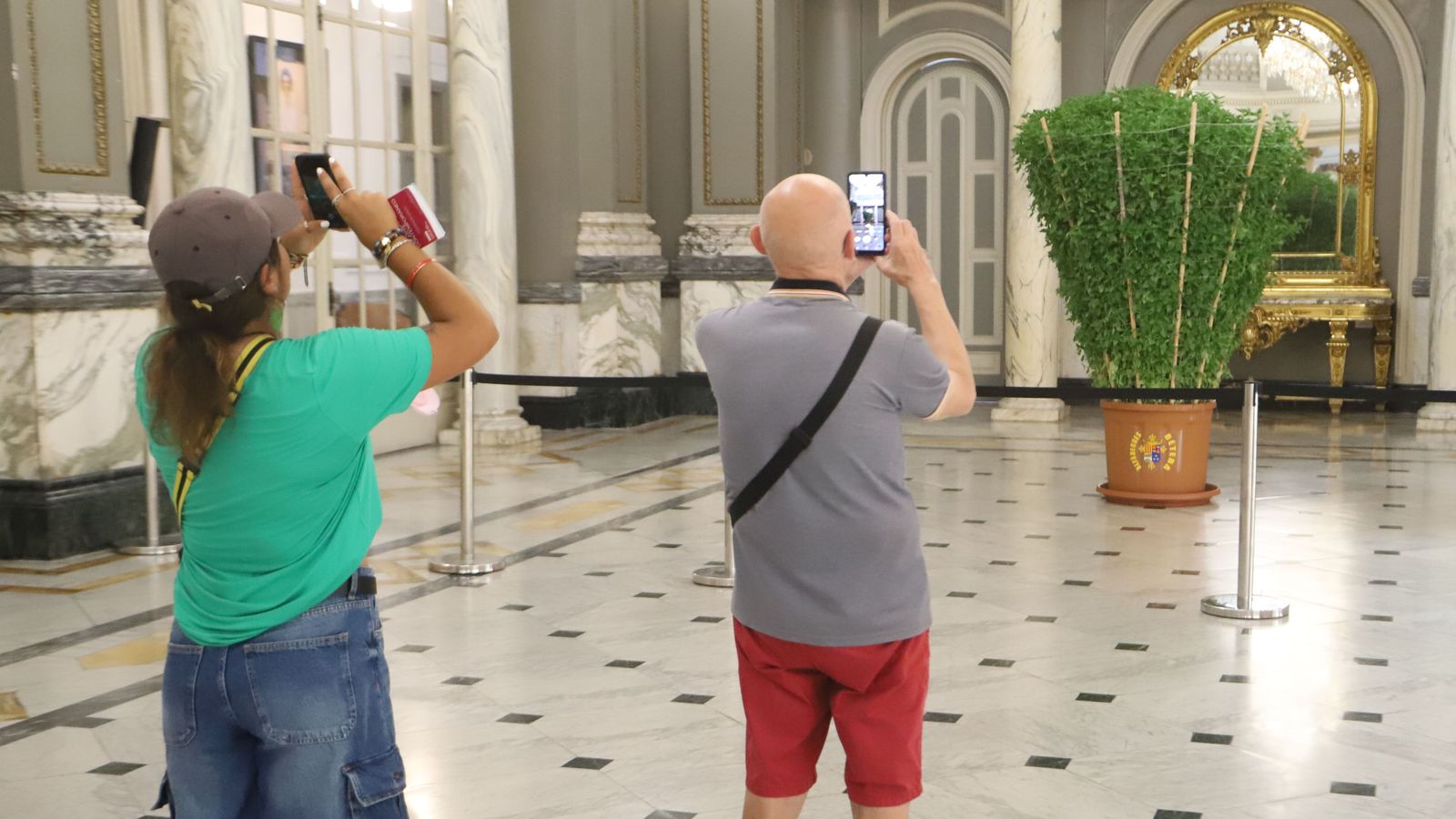 Dos visitants fotografien l'alfàbega que ha regalat Bétera a l'Ajuntament de València