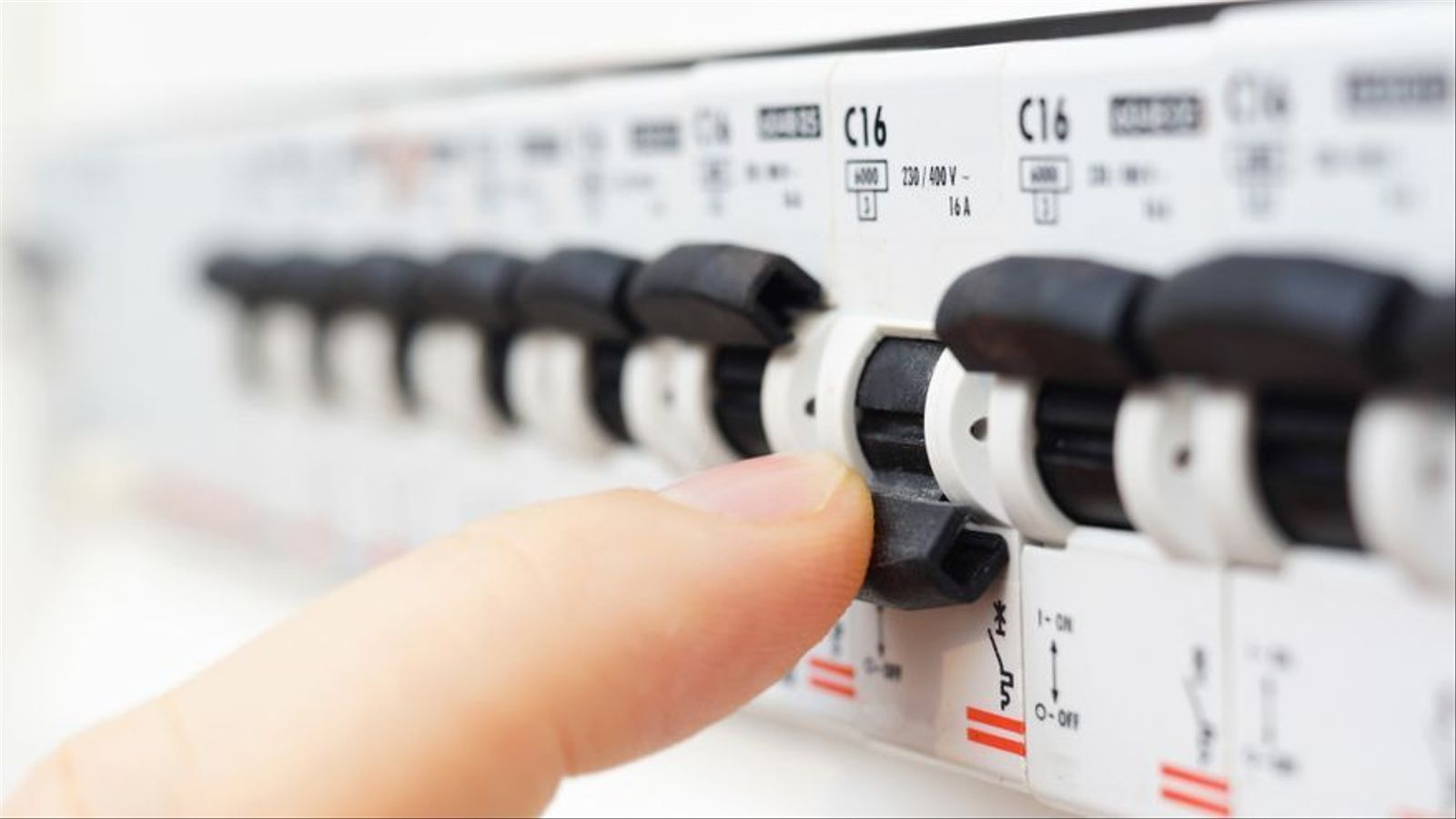 Una persona desconnecta un comptador de la llum / Bacho (Shutterstock)