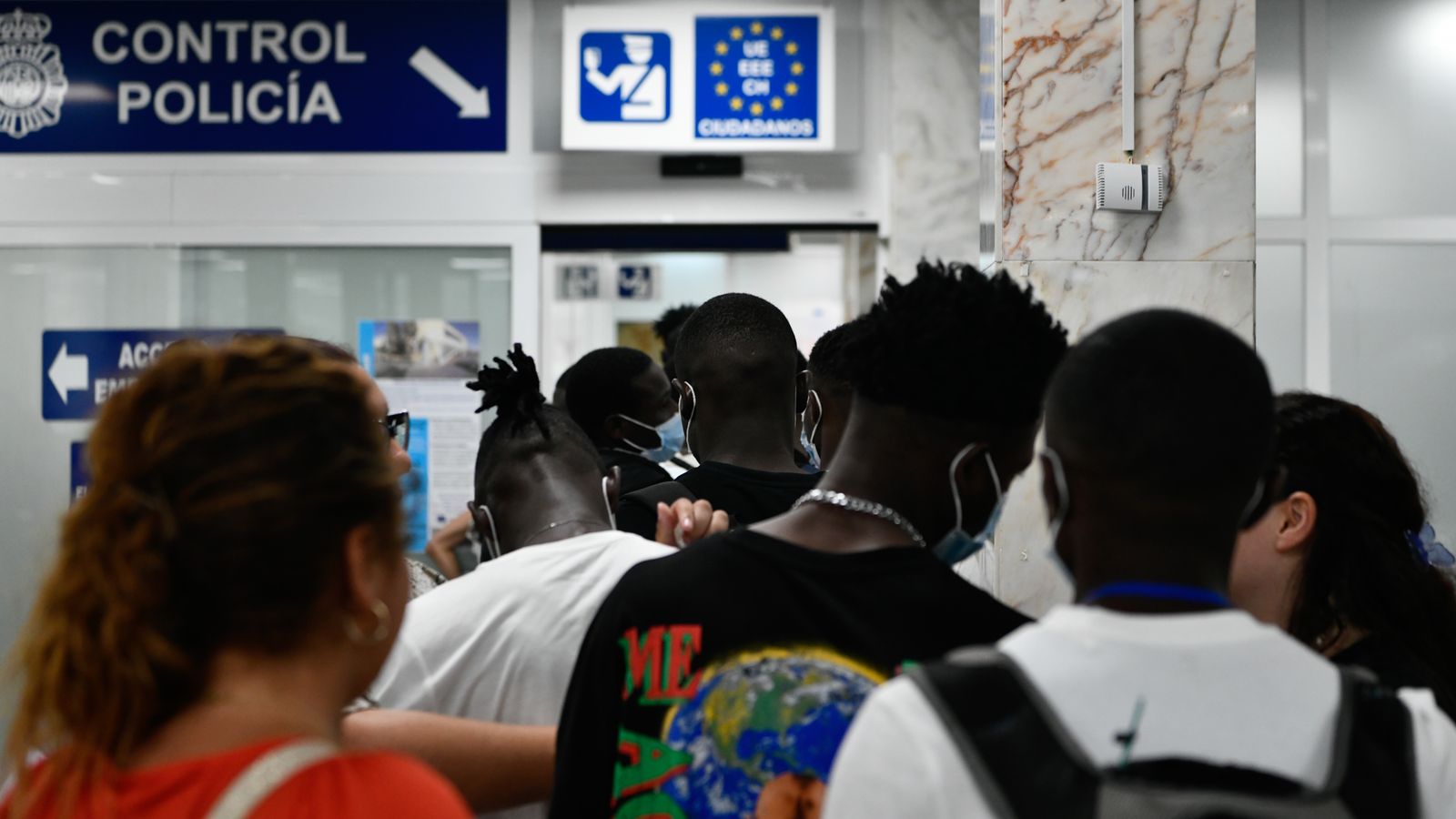 En una imatge d'arxiu, un grup de persones amb protecció d'asil passa un control policial