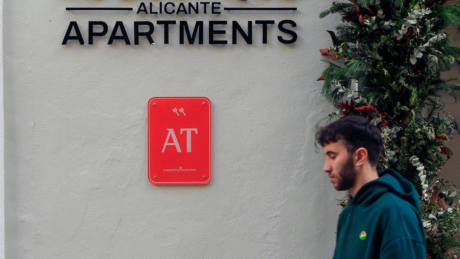 Un jove passa per davant d'un bloc d'apartaments turístics a Alacant