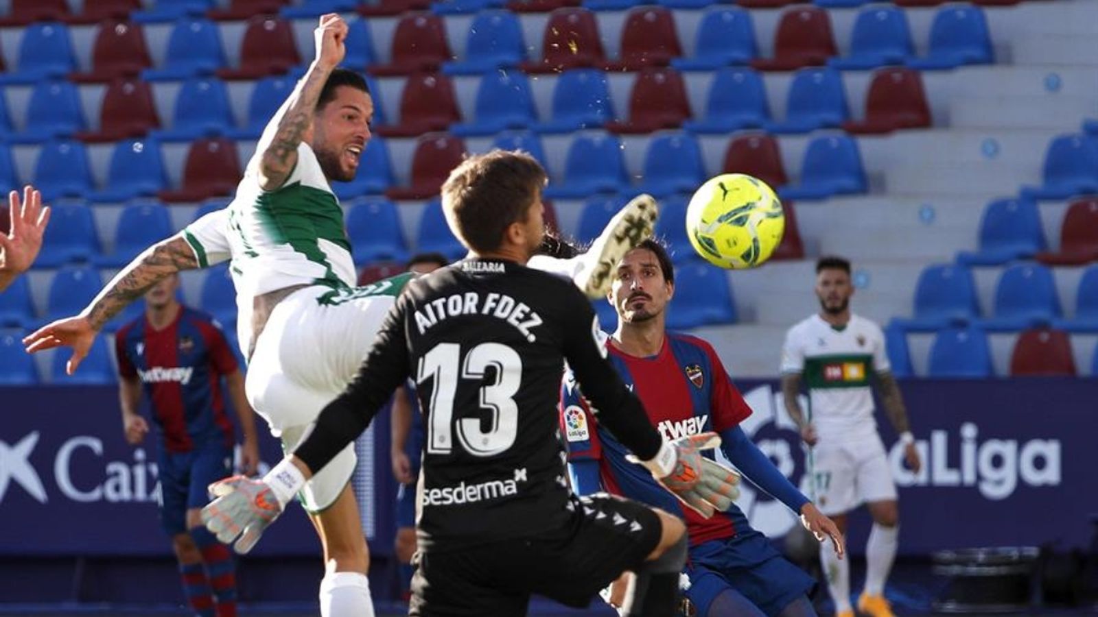 El porter del Llevant, Aitor Fernández, tracta d'evitar el gol del jugador de l'Elx, Tete Morente