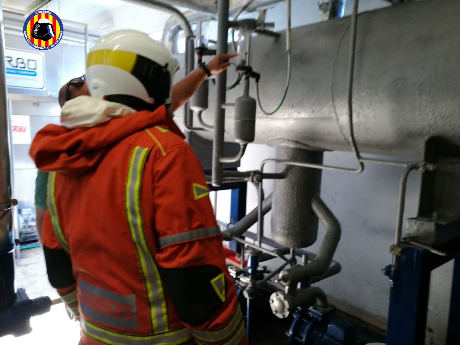 Dos efectius inspeccionen una de les màquines de la fàbrica de gel afectada
