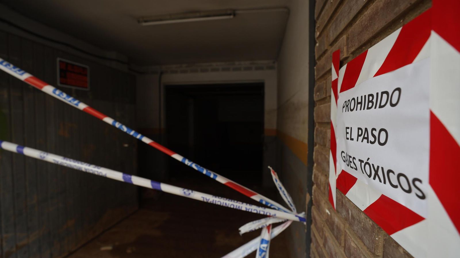 Un cartell avisa dels gasos tòxics durant la neteja de llot en un garatge a Paiporta