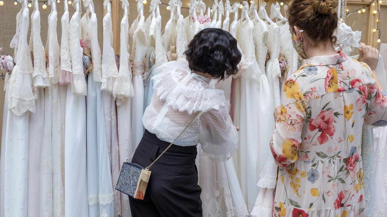 Una clienta revisa un expositor de vestuari de comunió a FIMI, en una imatge d'arxiu