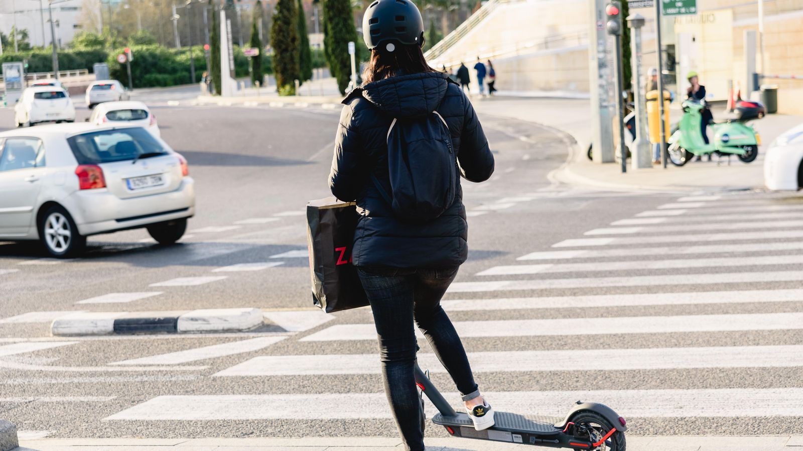 Una dona amb un patinet elèctric en la Ciutat de les Ciències de València