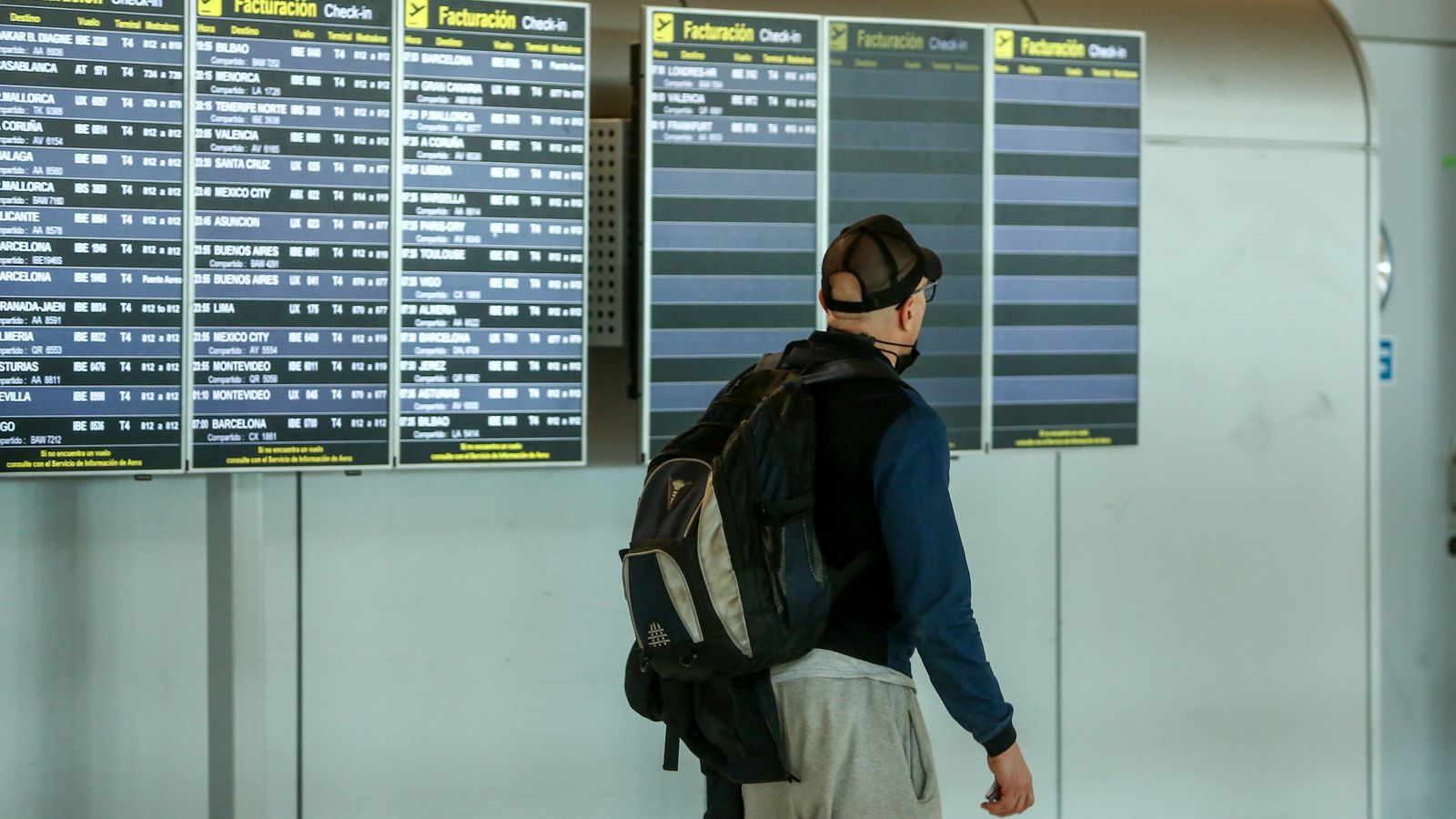 Un home mira vols a l'aeroport