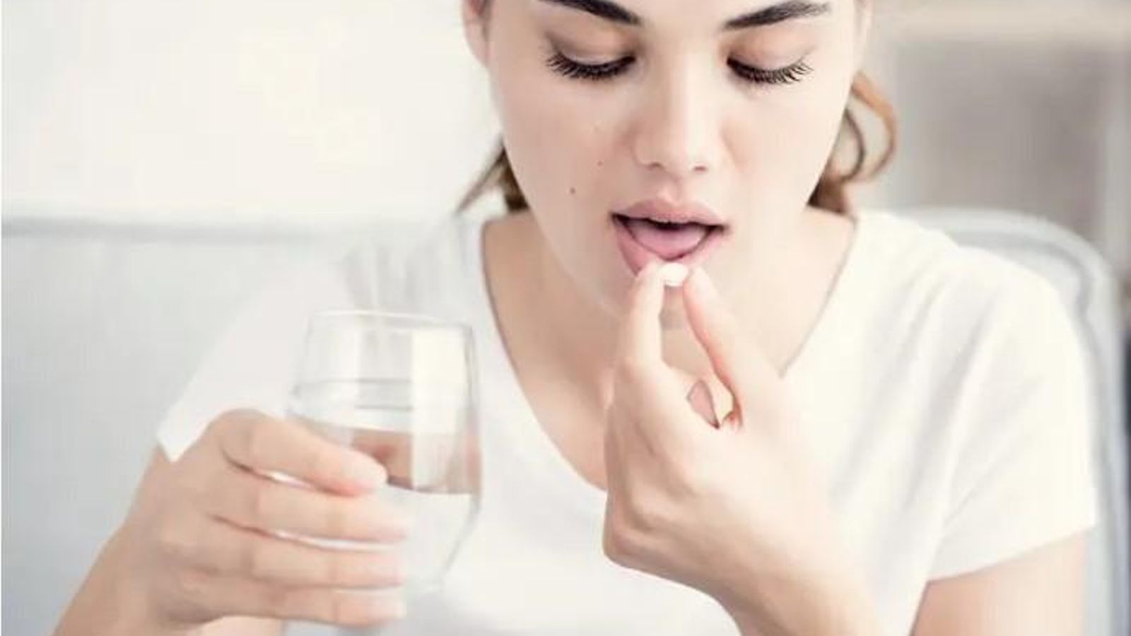 Una dona es pren una aspirina