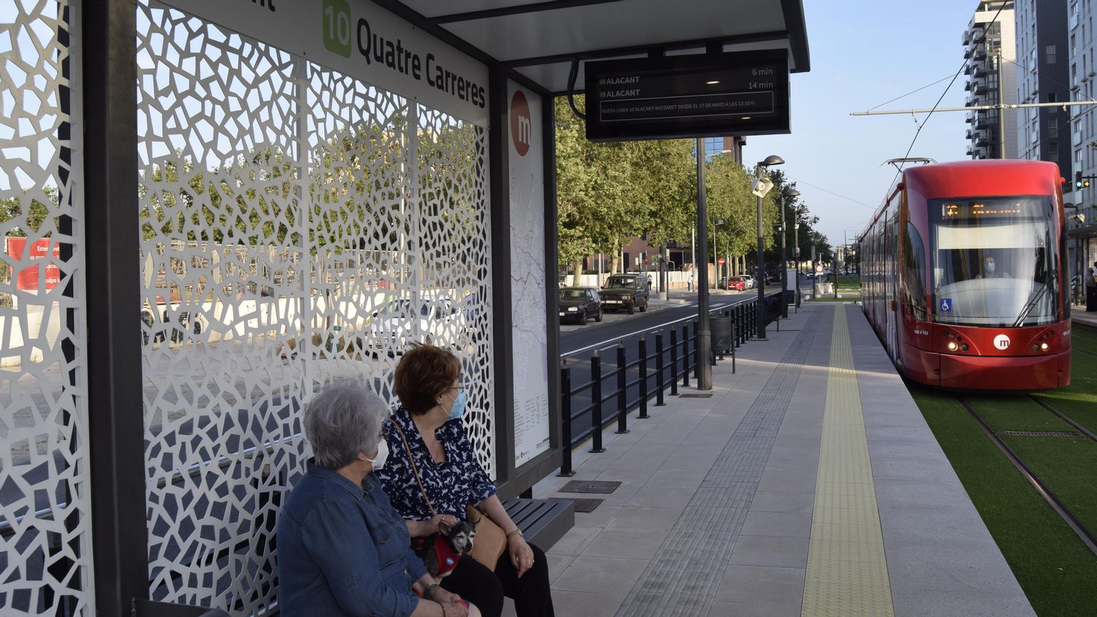 Dues persones esperen a una parada de la nova Línia 10 de Metrovalència