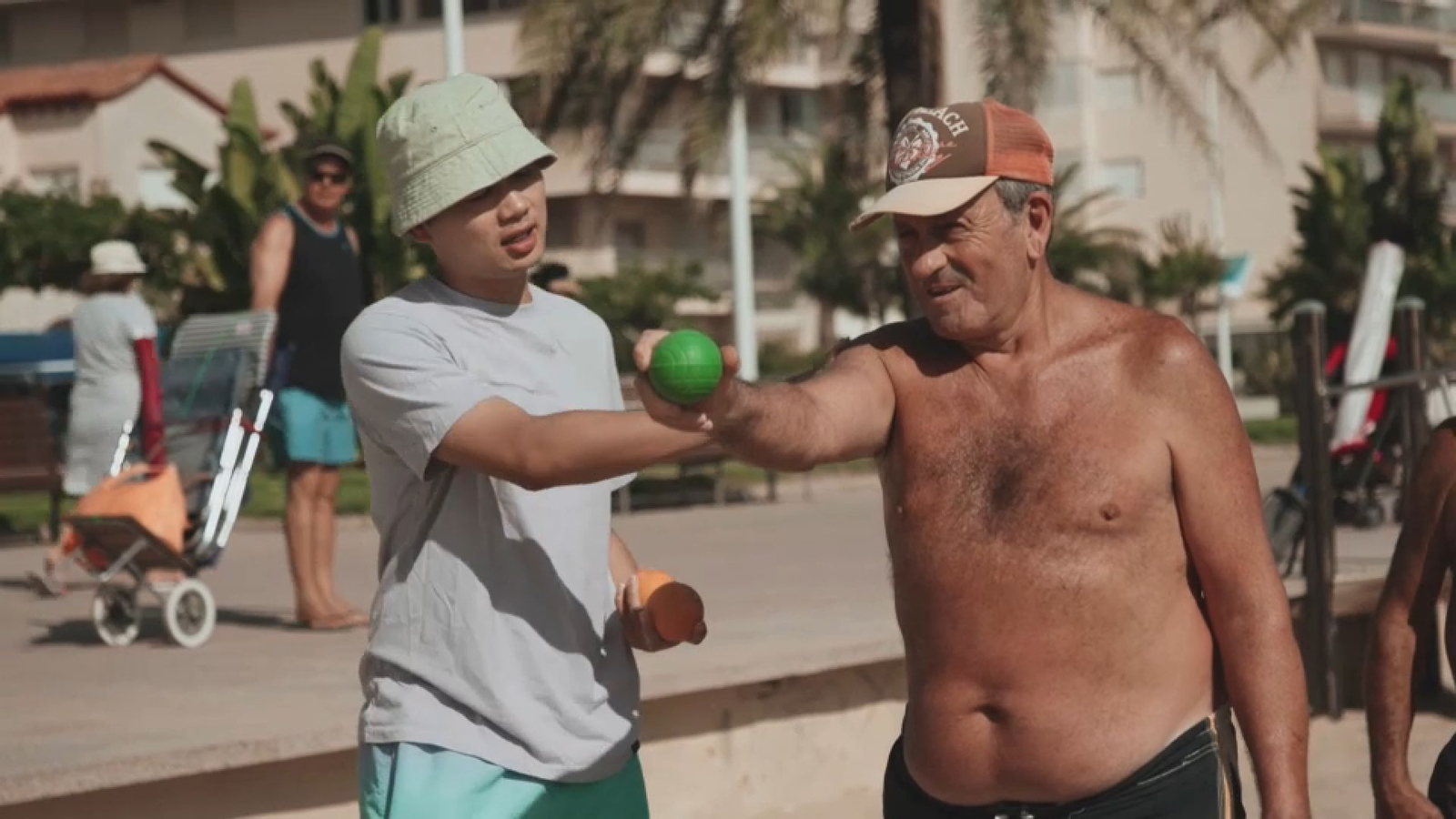 Coneix com anima Hu Zhao als jugadors de petanca, a la platja de Gandia