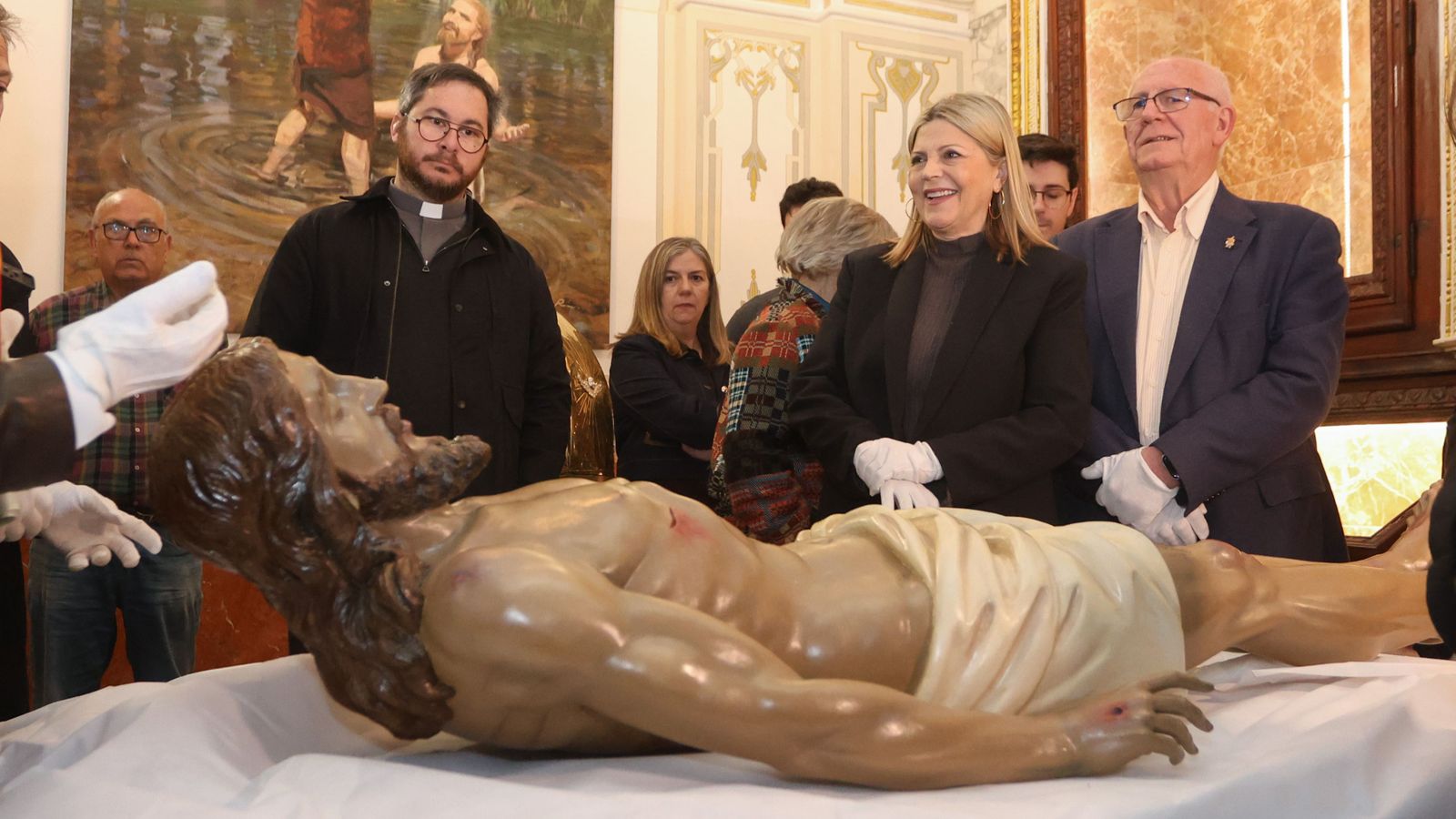 La consellera Ortí escolta les explicació de l'equip de restauradors que ha recuperat el Crist dels efectes de la riuada