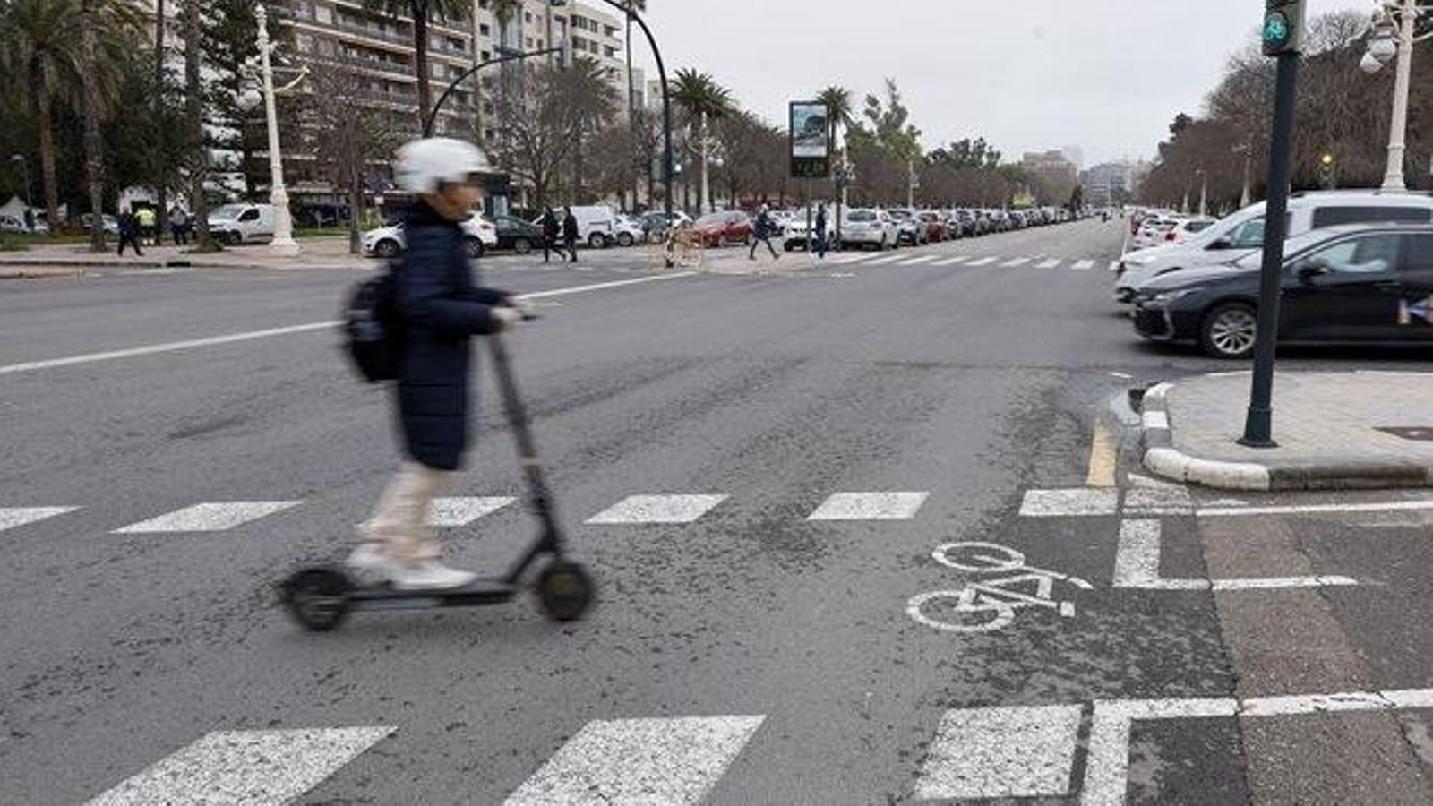 Un xiquet travessa el pas de zebra amb un patinet Un xiquet travessa el pas de zebra amb un patinet
