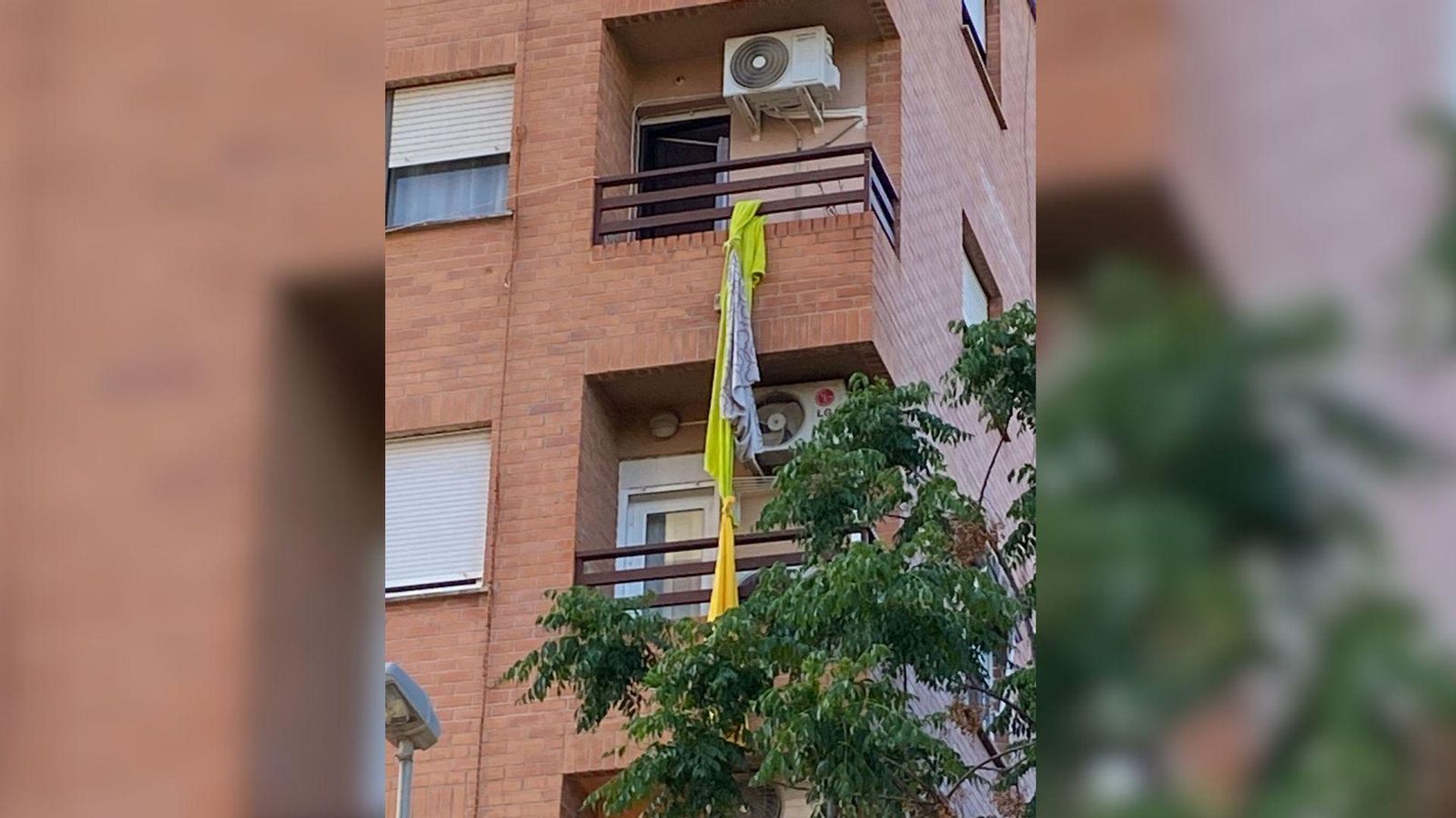 En imatge, el balcó des del que s'ha precipitat l'home amb la corda de llençols i tovalles penjant