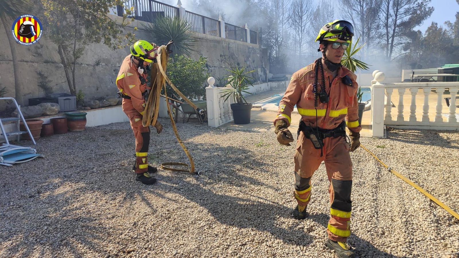 Els bombers treballen per a evitar que les flames s'acosten a les vivendes