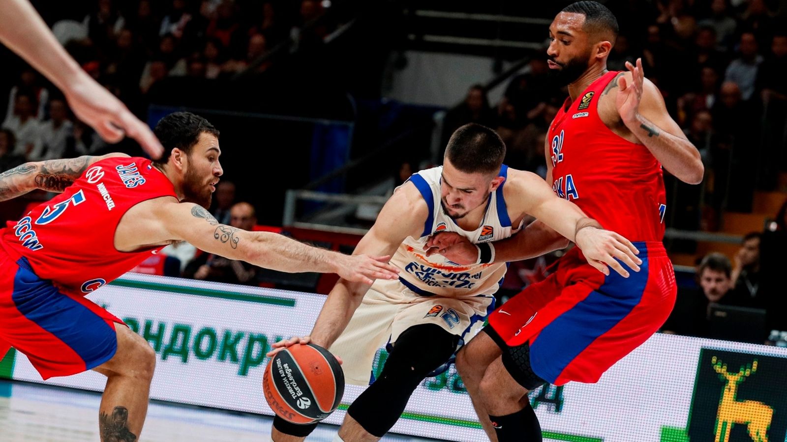 Acció del taronja Vanja Marinkovic, contra els jugadors dels CSKA, Mike James i Darrun Hilliard