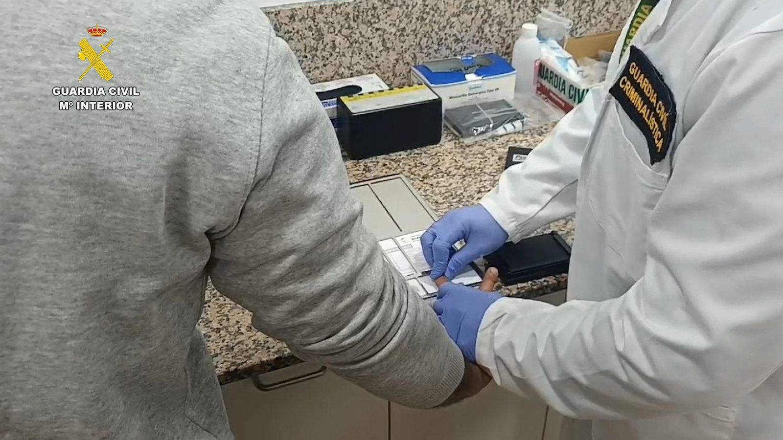 Un agent pren les empremtes dactilars a un dels detinguts