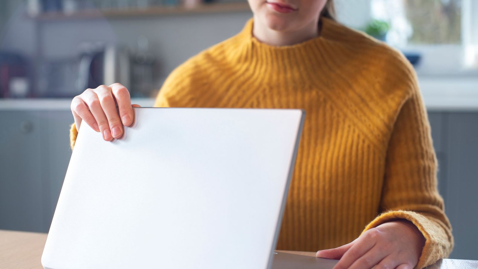 Xiqueta obrint un ordinador portàtil en una imatge d'arxiu