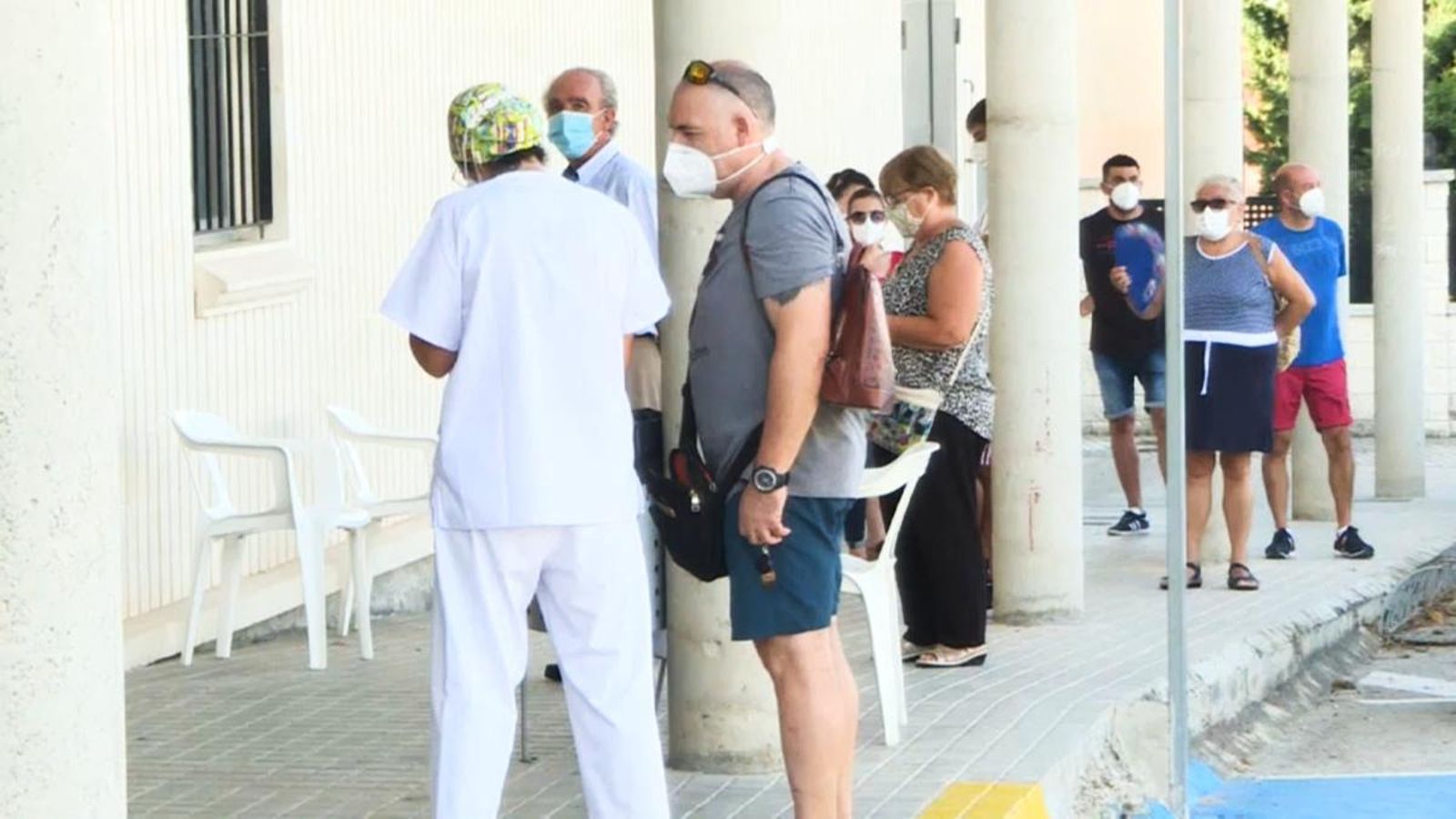 Un grup de veïns i veïnes de Benigànim fan cua a l'espera que els facen la prova de PCR