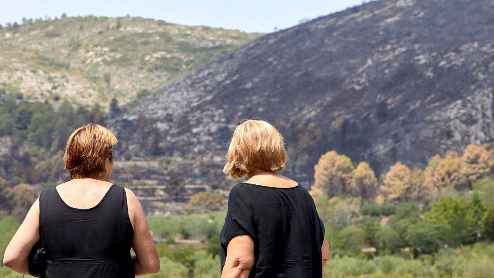 Dues veïnes de Pinet observen com ha quedat el paisatge després del pas de les flames