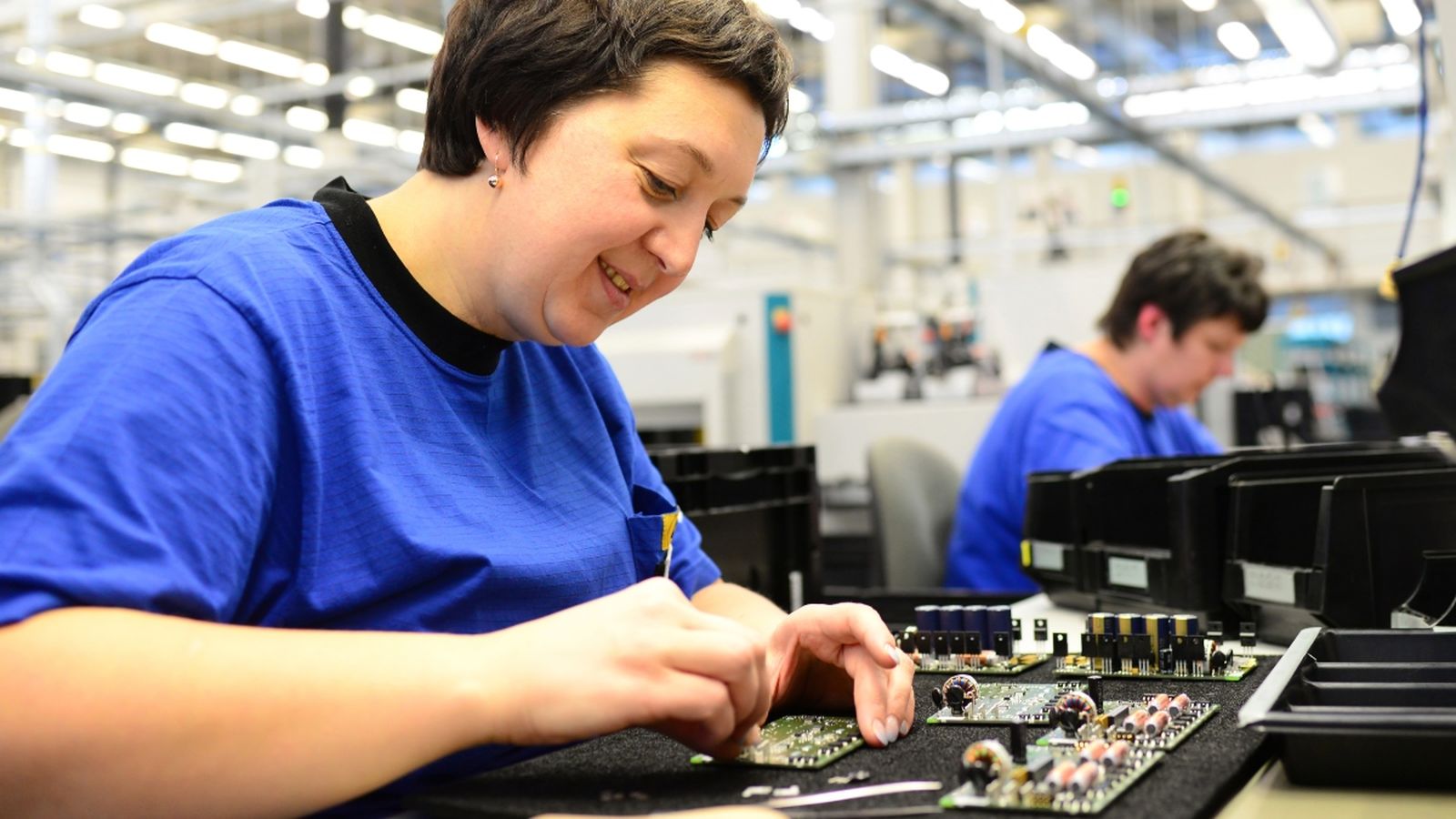 Dues treballadores de la cadena de muntatge de microelectrònica en una fàbrica d'alta tecnologia