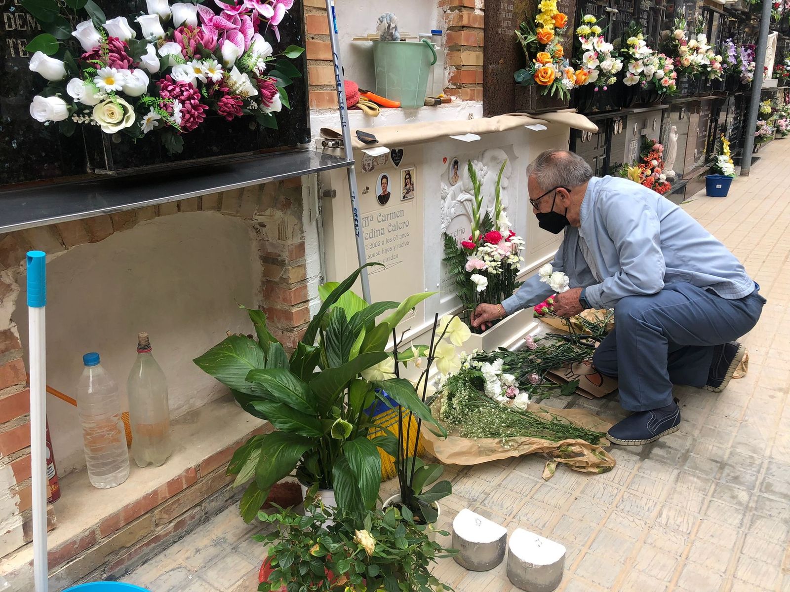 Un home posa flors en un nínxol