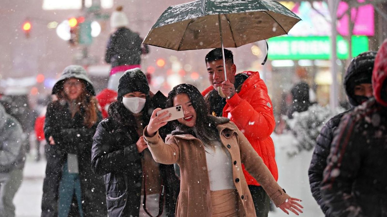 La gent posa per a les fotos mentre cau la neu a Nova York, estat més colpejat pel coronavirus