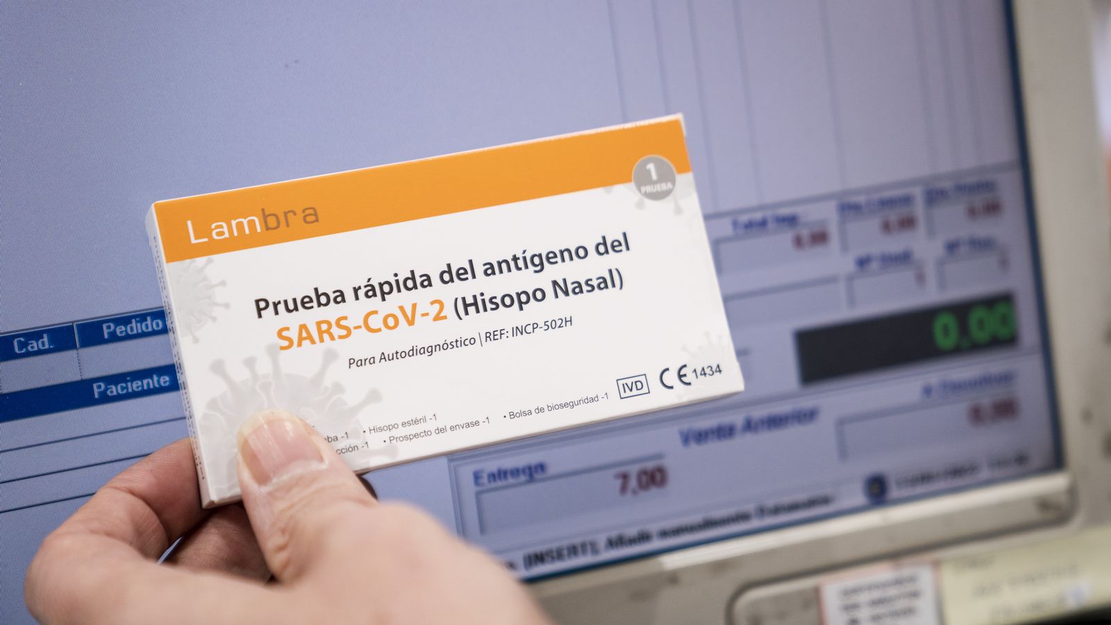 Un professional subjecta un test d'antígens dels que venen en les farmàcies