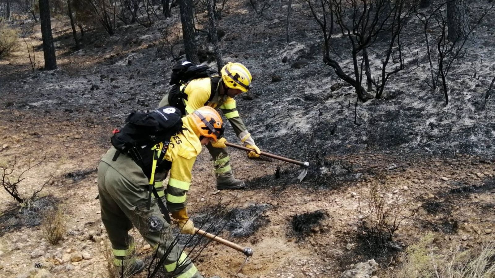 Dos bombers treballen en tasques d'extinció del foc a Venta del Moro