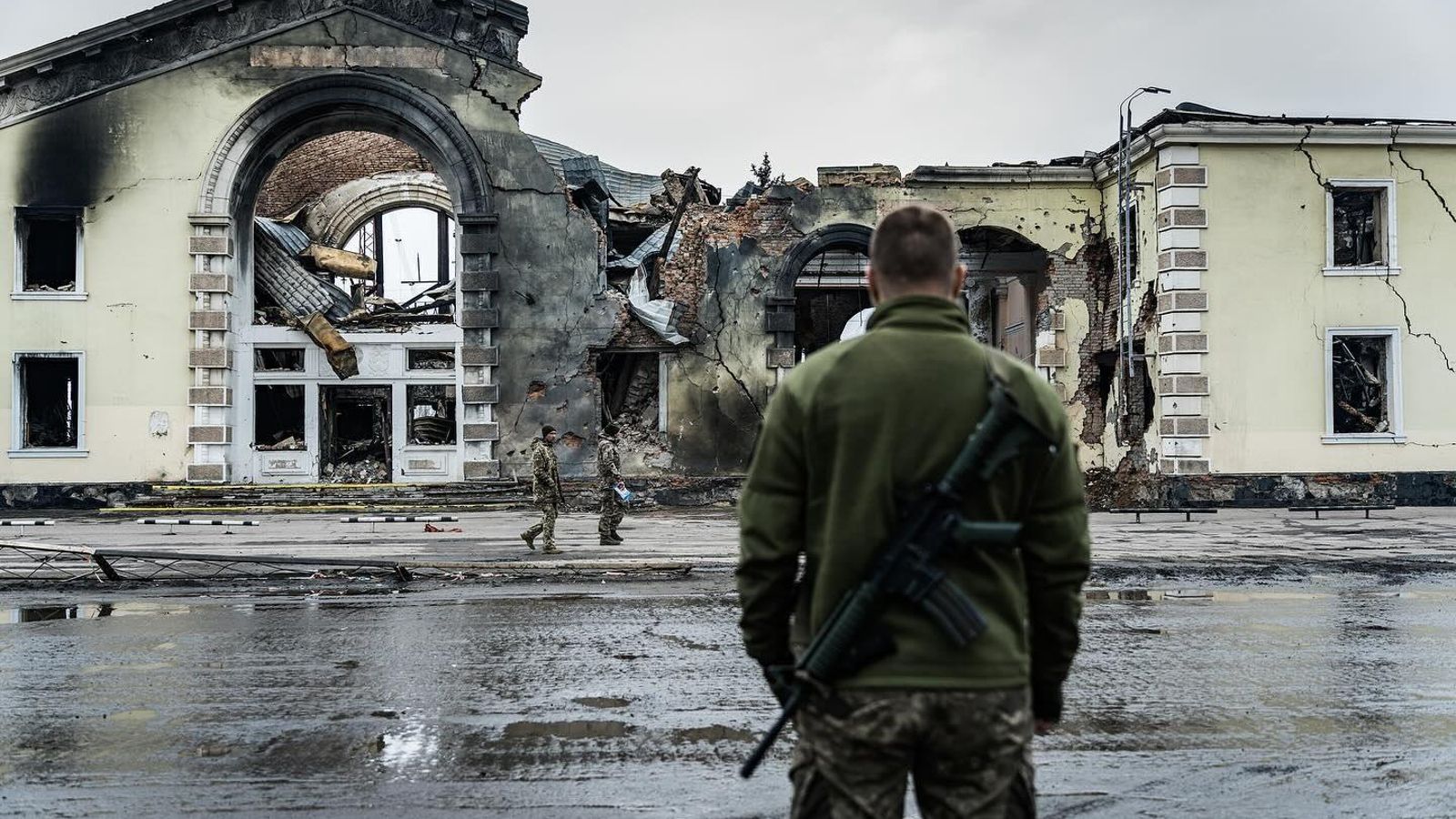 Un soldat ucraïnés observa edificis destruïts pels bombardejos russos