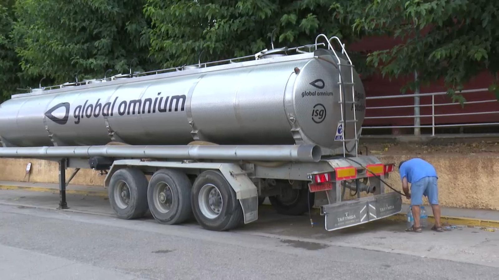 Un veí de Vilamarxant omple garrafes d'aigua d'un camió cisterna