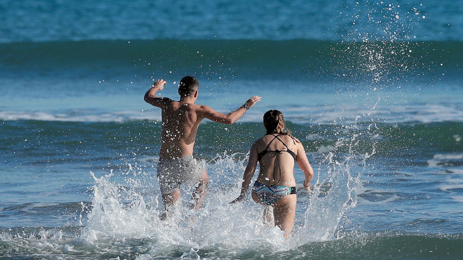 Una parella s'endinsa en la mar a la platja de la Malva-rosa, en una imatge de dimarts passat