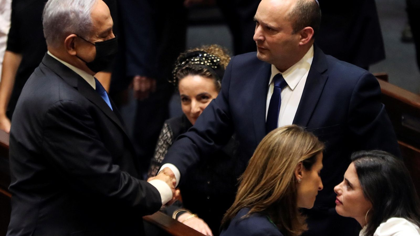 El nou ministre Neftali Bennett encaixa mans amb el mandatari sortint, Benjamin Netanyahu, al parlament israelià
