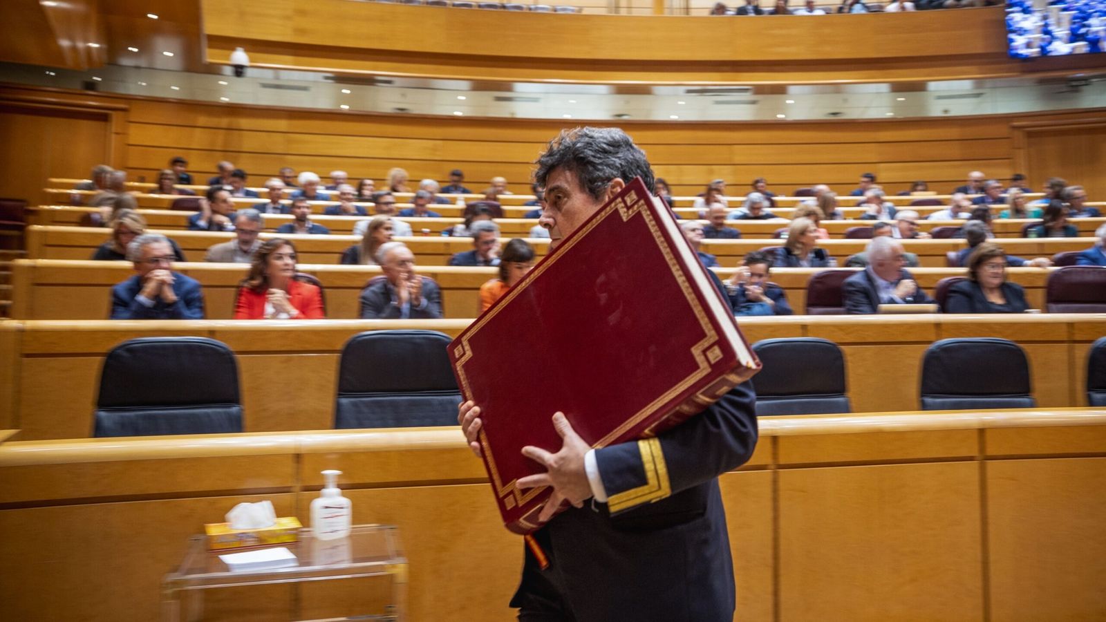 Un ujier del Senat retira la Constitució espanyola de 1978 de la sala del ple després del jurament d’un nou senador.