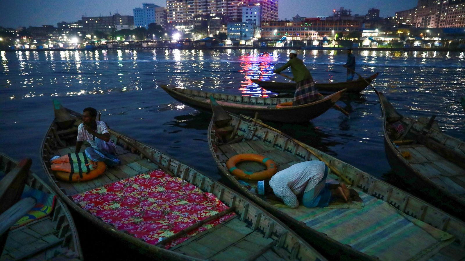 Imatge nocturna d'un dels rius amb transport fluvial a Bangladesh