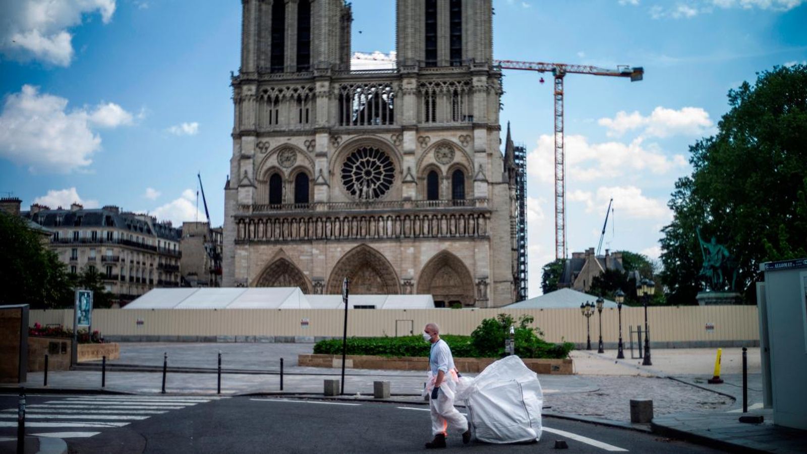 Un treballador passa per davant de la catedral de Notre-Dame, a París