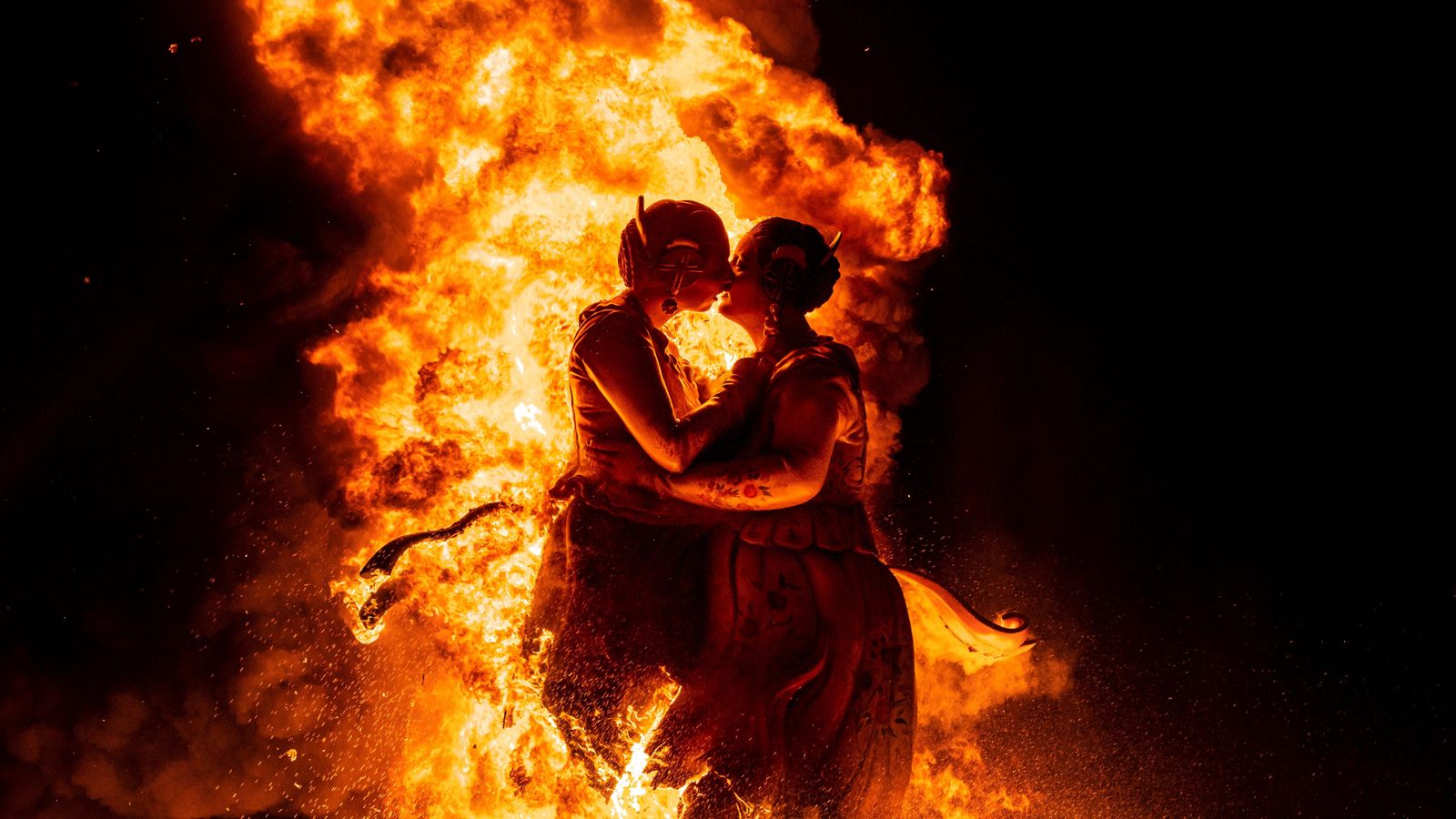 El bes de dues dones vestides de falleres d'una falla de Torrent (València) durant la Cremà