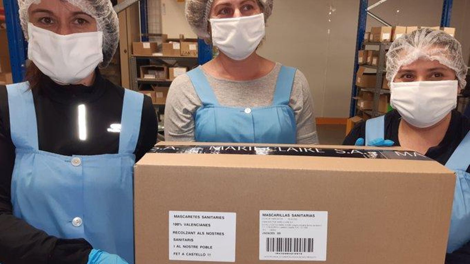 Treballadores de Marie Claire amb una de les capses de mascaretes confeccionades per l'empresa