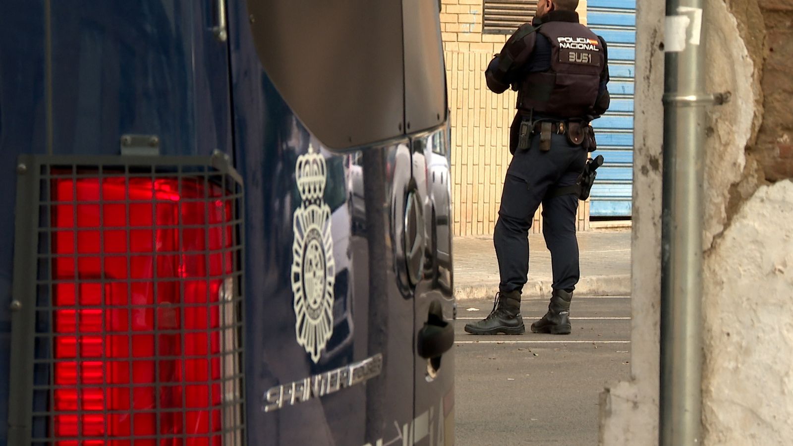 Un policia, junt a un furgó policial, en una imatge d'arxiu