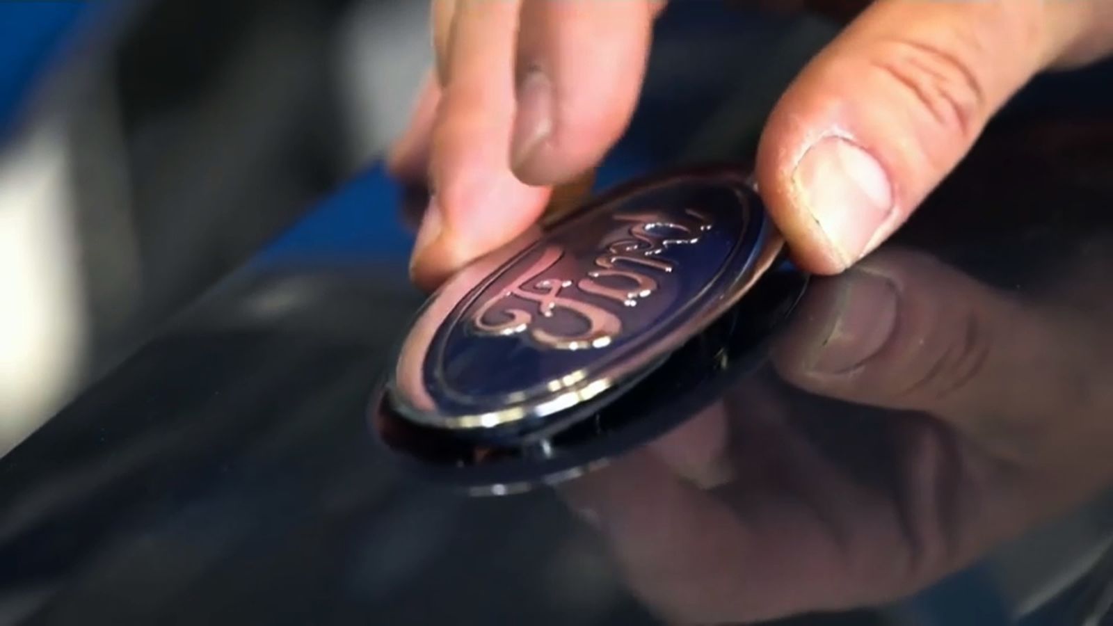 Un operari de Ford Almussafes col·loca l'emblema de la companyia en un vehicle