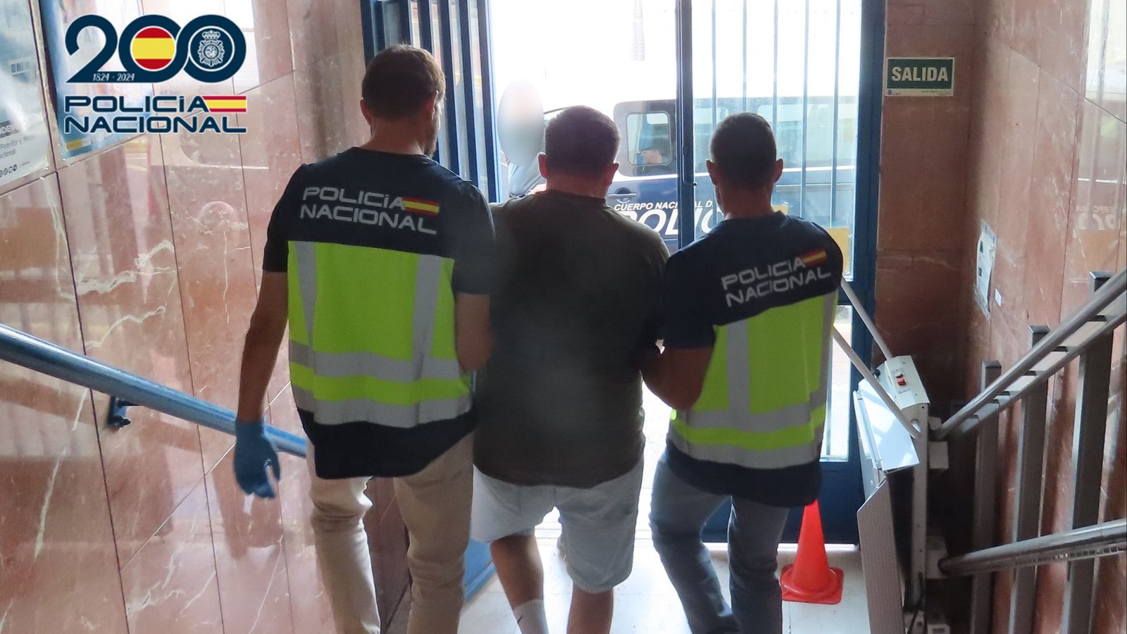 Agents de la Policia Nacional acompanyen el detingut al furgó policial