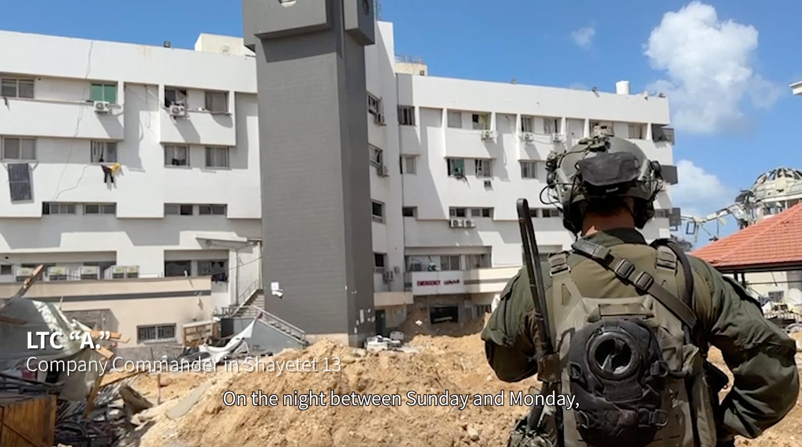 Un militar israelià contempla l'hospital Al-Shifa, davant una de les portes d'emergències