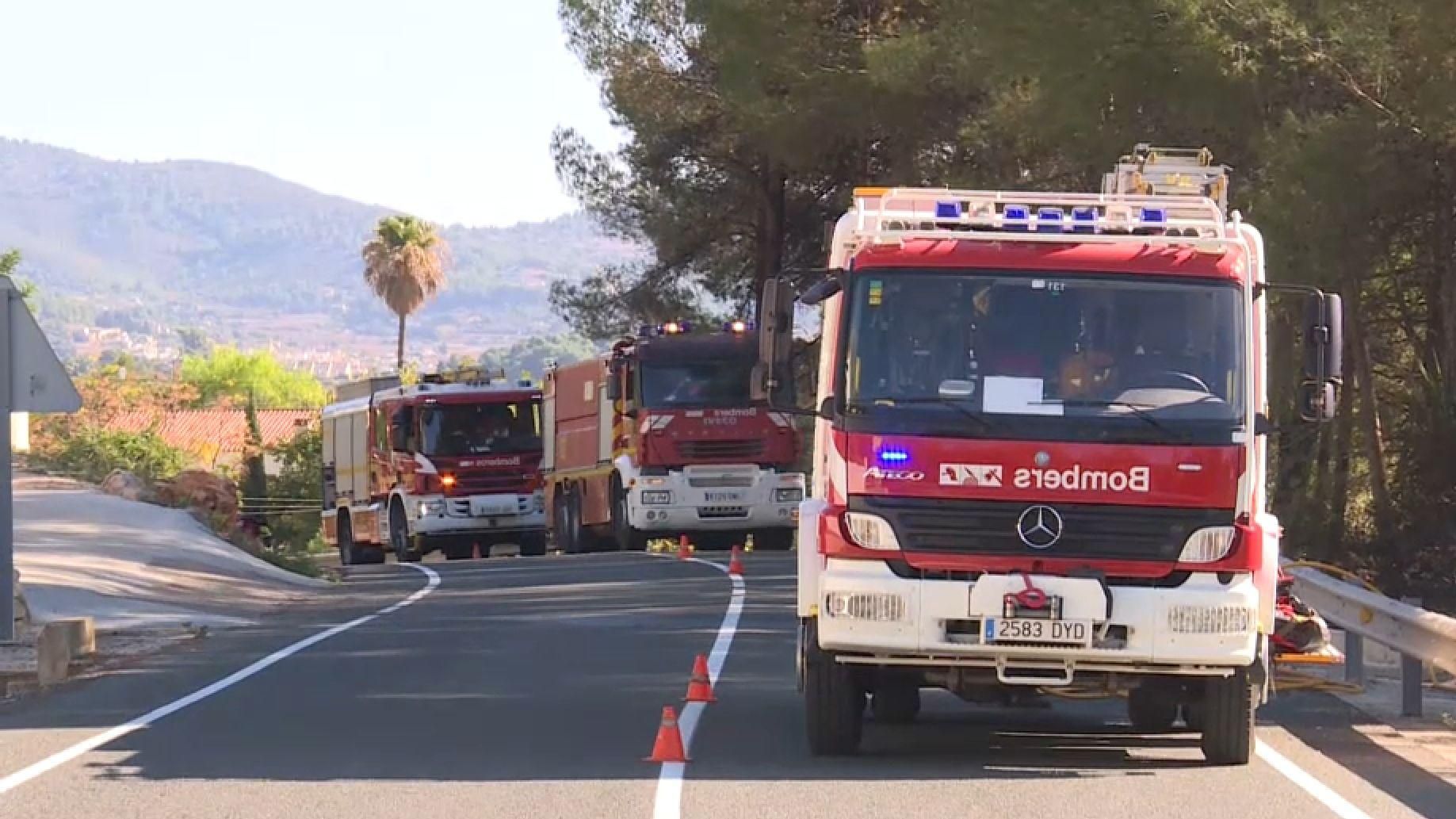 Diversos camions de bombers tracten de sufocar totalment l'incendi sorgit junt a la carretera d'accés a Alcalalí