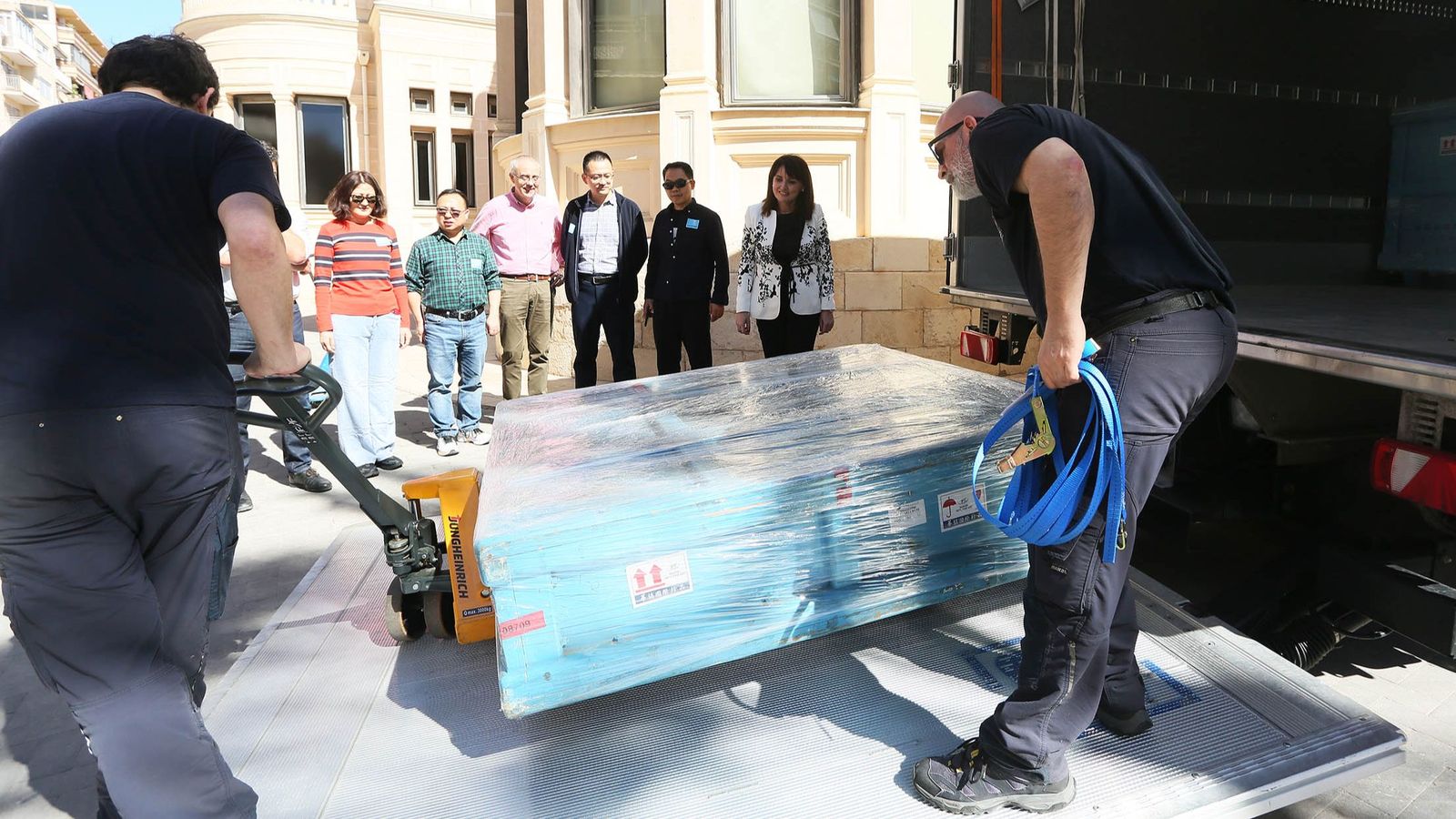 Els operaris descarreguen una de les caixes amb els fons de l'exposició dels guerrers de Xian sota la mirada dels responsables dels museus xinesos i el Marq