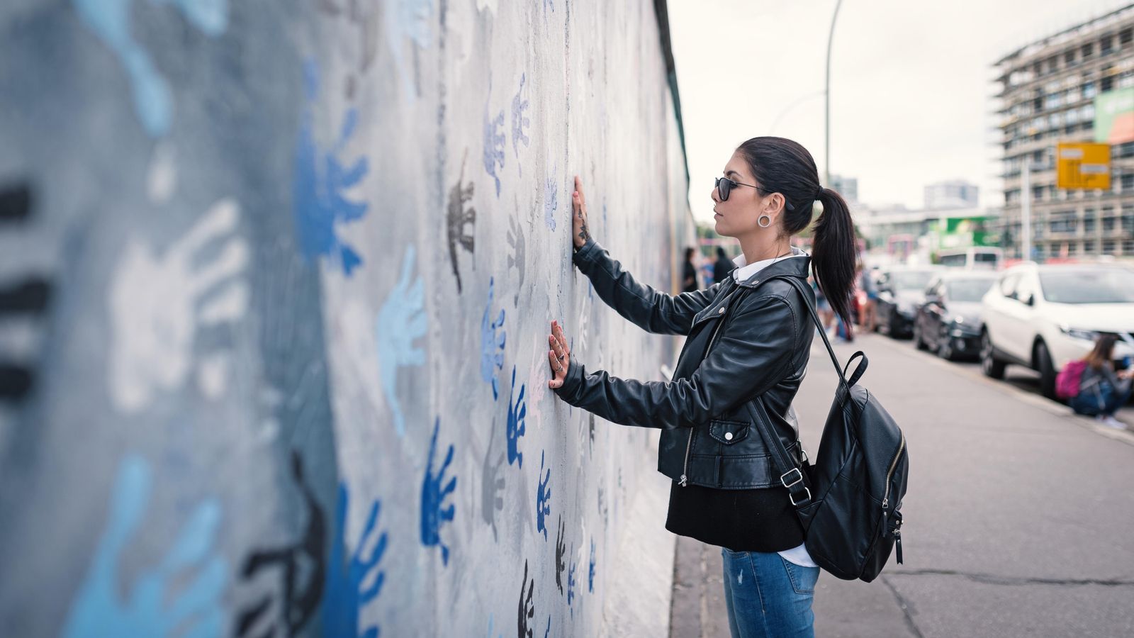 Una dona deixa la seua petjada al mur de Berlín