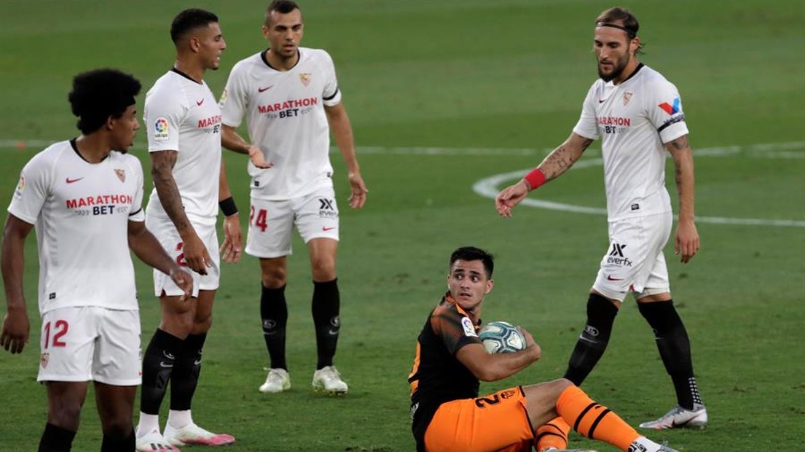 Maxi López en terra rodejat de jugadors del Sevilla